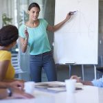 woman pointing at white board